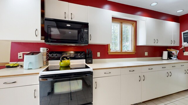 5 Wilson St, Lewiston, ME 04240 - kitchen with black microwave, range with electric stovetop, light countertops, and white cabinets