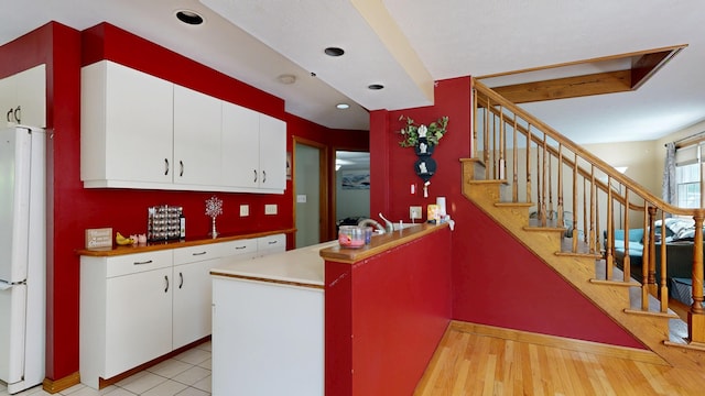 5 Wilson St, Lewiston, ME 04240 - kitchen with freestanding refrigerator, a peninsula, white cabinetry, and recessed lighting