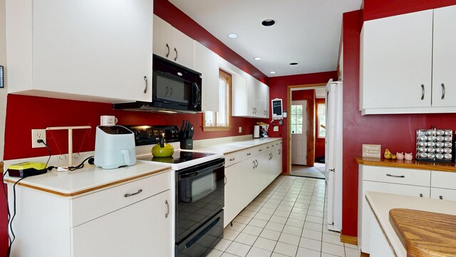 5 Wilson St, Lewiston, ME 04240 - kitchen featuring electric range, black microwave, white cabinets, light countertops, and light tile patterned flooring