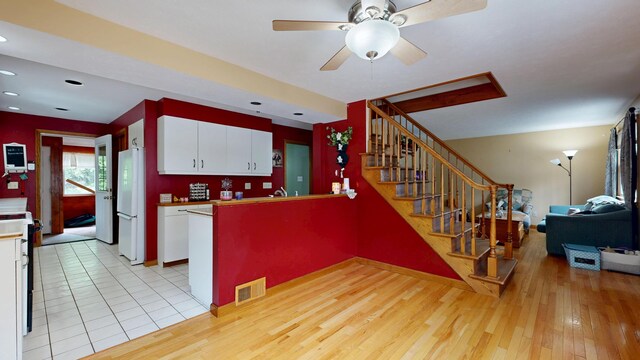 5 Wilson St, Lewiston, ME 04240 - kitchen with freestanding refrigerator, white cabinets, light wood-style floors, a peninsula, and recessed lighting