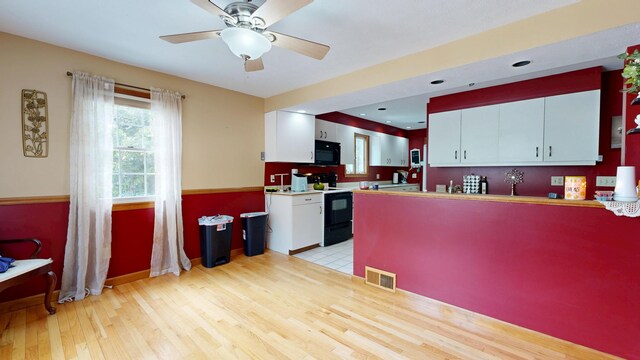 5 Wilson St, Lewiston, ME 04240 - kitchen featuring electric range oven, black microwave, light wood finished floors, a peninsula, and white cabinets