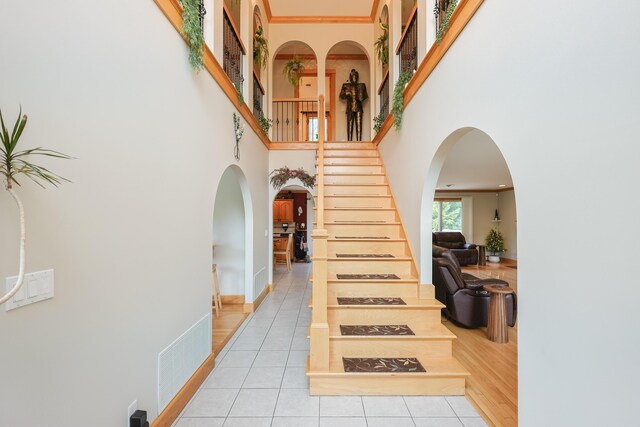 6 Grande Ave, Lewiston, ME 04240 - stairs featuring a towering ceiling, tile patterned floors, arched walkways, and crown molding