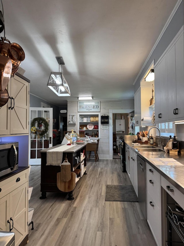 164 Lancey St, Pittsfield, ME 04967 - kitchen with stainless steel microwave, dishwashing machine, wood finished floors, ornamental molding, and hanging light fixtures