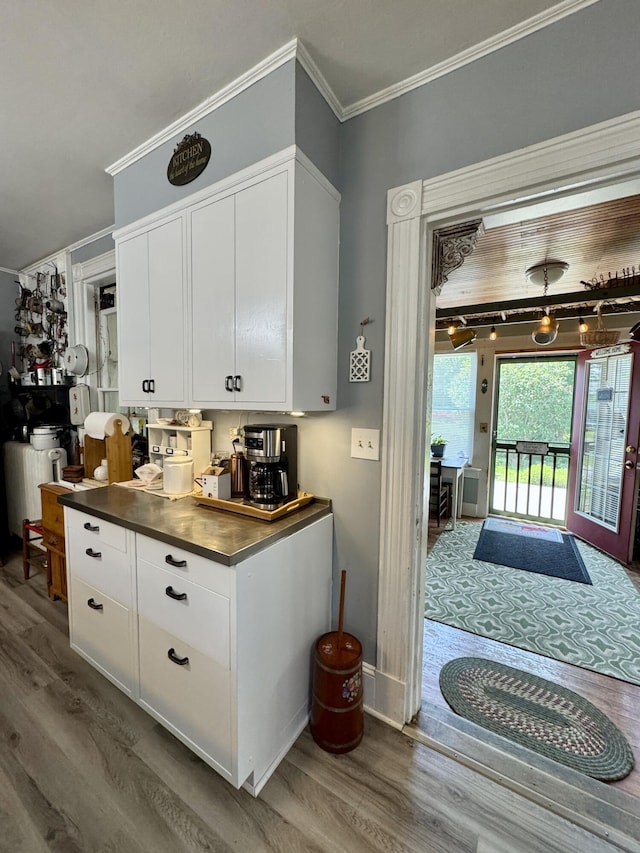 164 Lancey St, Pittsfield, ME 04967 - kitchen with wood finished floors, white cabinetry, ornamental molding, and dark countertops