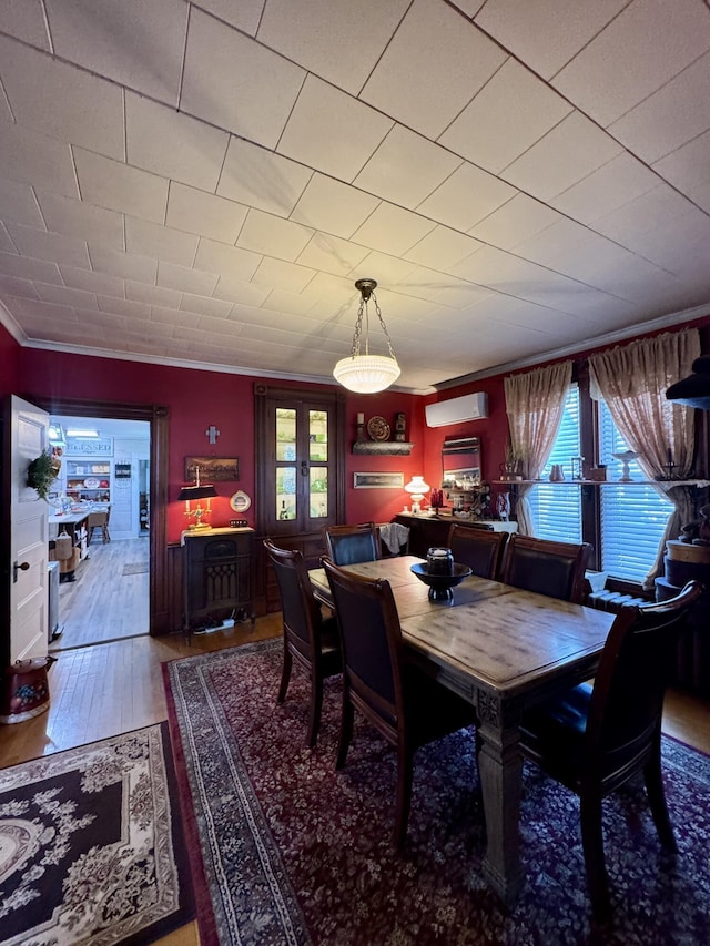 164 Lancey St, Pittsfield, ME 04967 - dining space featuring a wall unit AC, crown molding, french doors, and wood finished floors