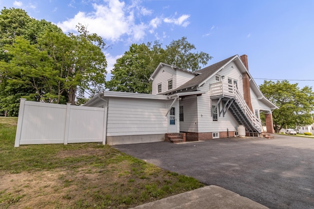 3 Dion St, Lewiston, ME 04240 - view of front of property featuring a chimney, driveway, a shingled roof, and entry steps
