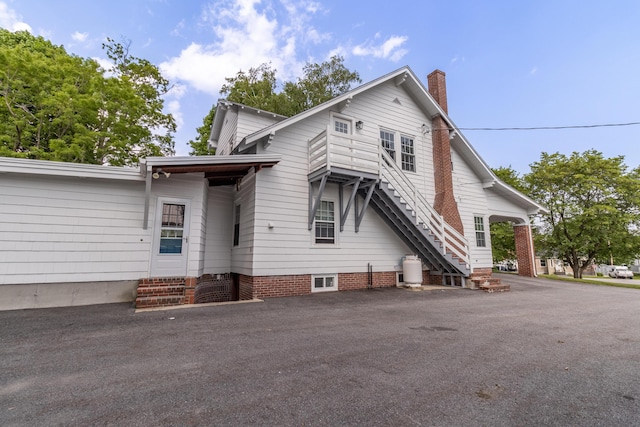 3 Dion St, Lewiston, ME 04240 - view of side of home with a chimney, stairs, and entry steps