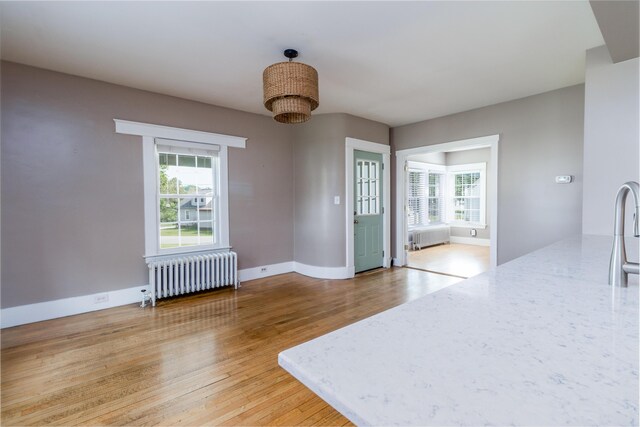 3 Dion St, Lewiston, ME 04240 - unfurnished dining area with radiator heating unit, plenty of natural light, and light wood-style flooring