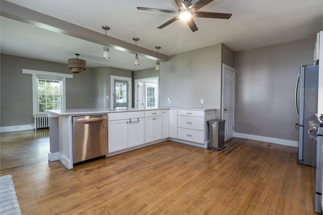 3 Dion St, Lewiston, ME 04240 - kitchen with dishwasher, radiator heating unit, a peninsula, white cabinetry, and a ceiling fan