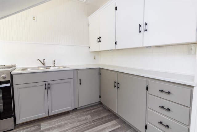 3 Dion St, Lewiston, ME 04240 - kitchen featuring gray cabinets, electric range oven, light countertops, light wood-style flooring, and decorative backsplash
