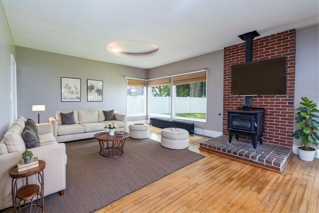 3 Dion St, Lewiston, ME 04240 - living room featuring a wood stove, radiator, and hardwood / wood-style floors