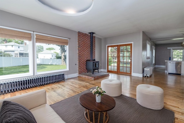 3 Dion St, Lewiston, ME 04240 - living area featuring radiator heating unit, a wood stove, and wood finished floors