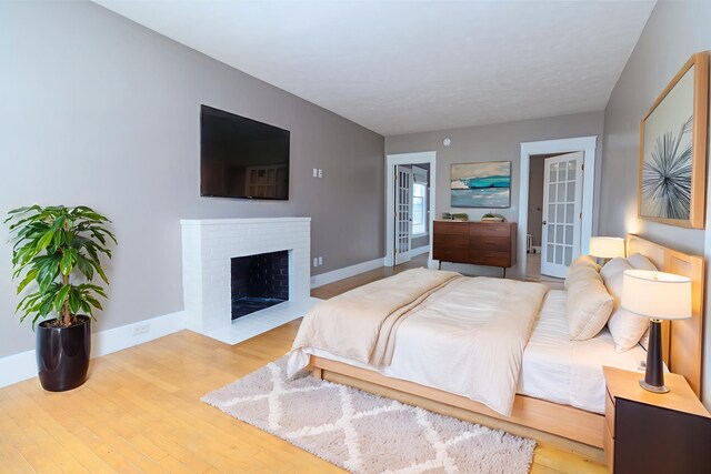 3 Dion St, Lewiston, ME 04240 - bedroom with french doors, wood finished floors, and a brick fireplace