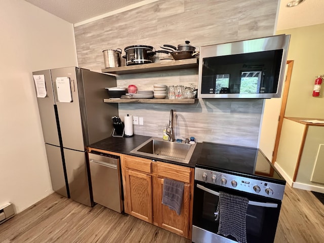 8 Fall Line Dr Unit N211, Newry, ME 04261 - kitchen with stainless steel appliances, dark countertops, light wood-style flooring, backsplash, and a baseboard heating unit