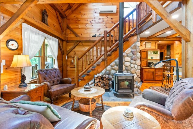 32 Lake Como Dr, Harmony, ME 04942 - living room with light wood-type flooring, wooden walls, stairway, a wood stove, and a wall mounted AC