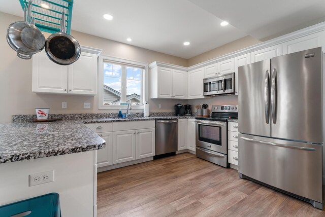 8 Studley Ln, Wells, ME 04090 - kitchen featuring appliances with stainless steel finishes, white cabinetry, light wood finished floors, dark stone countertops, and recessed lighting