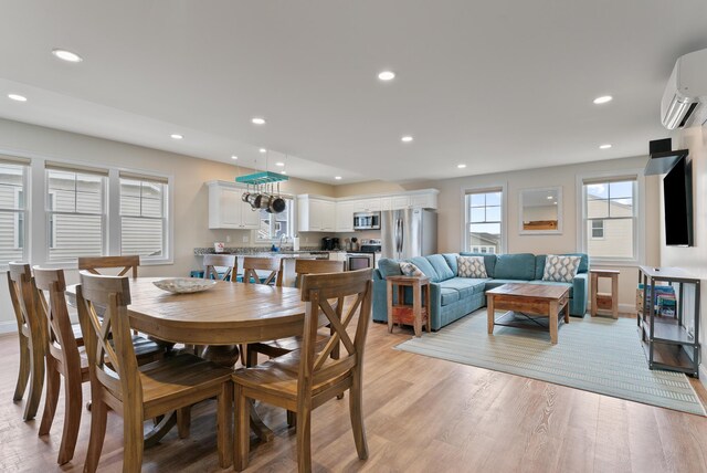 8 Studley Ln, Wells, ME 04090 - dining area featuring a wall unit AC, light wood-type flooring, and recessed lighting