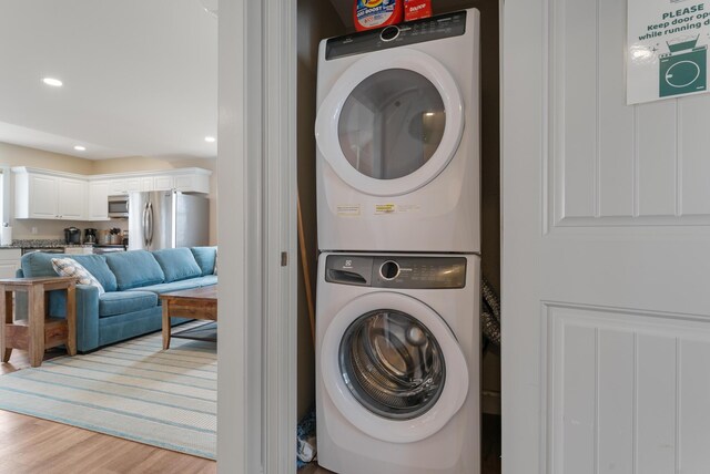 8 Studley Ln, Wells, ME 04090 - laundry room featuring stacked washing machine and dryer, light wood finished floors, and recessed lighting