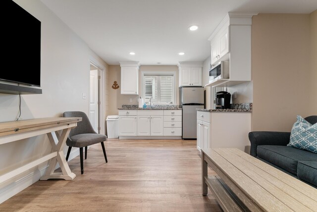 8 Studley Ln, Wells, ME 04090 - kitchen with freestanding refrigerator, white cabinets, light wood-type flooring, stone counters, and recessed lighting