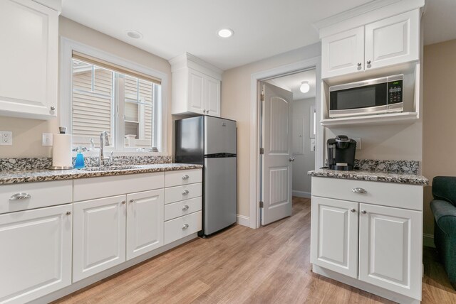 8 Studley Ln, Wells, ME 04090 - kitchen with appliances with stainless steel finishes, light wood finished floors, white cabinets, light stone countertops, and recessed lighting