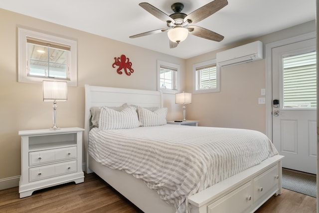 8 Studley Ln, Wells, ME 04090 - bedroom featuring a wall mounted AC, dark wood finished floors, and a ceiling fan