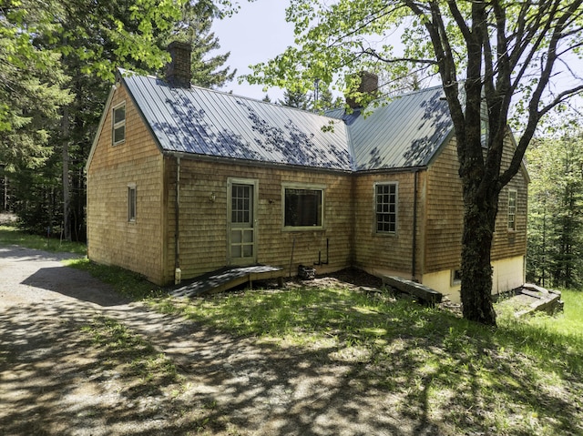 30 Wilkinson Ln, Machiasport, ME 04655 - view of property exterior featuring a chimney, a metal roof, and a standing seam roof