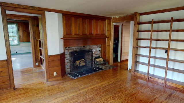 30 Wilkinson Ln, Machiasport, ME 04655 - unfurnished living room featuring light wood finished floors, a fireplace, and wooden walls