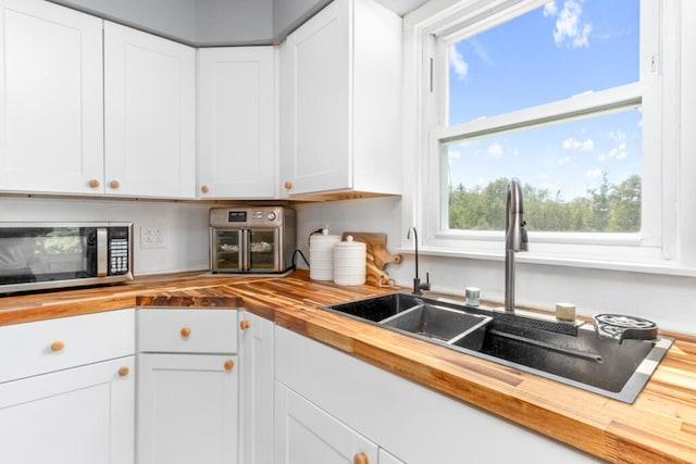 470 Main St, Waterville, ME 04901 - kitchen with butcher block countertops, stainless steel microwave, and white cabinets