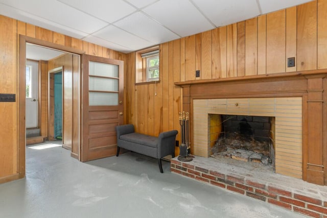 470 Main St, Waterville, ME 04901 - living room featuring unfinished concrete floors, wood walls, and a brick fireplace