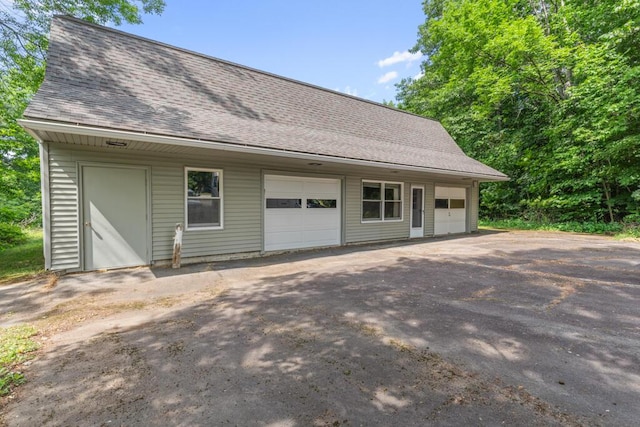 470 Main St, Waterville, ME 04901 - view of side of home with an outbuilding, a shingled roof, and an attached garage