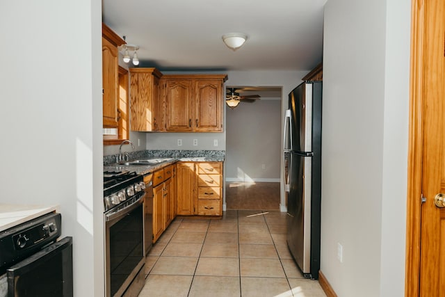 38 Swamp Rd, Bridgton, ME 04009 - kitchen featuring appliances with stainless steel finishes, light tile patterned flooring, brown cabinetry, and a ceiling fan