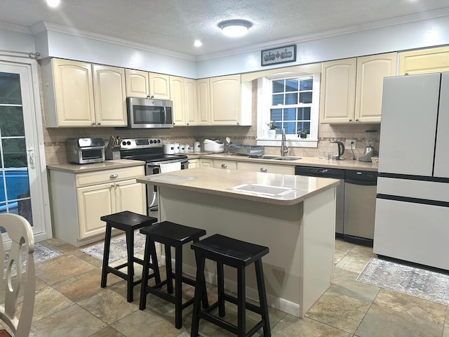 7 Lorraine Ave, Lewiston, ME 04240 - kitchen featuring stainless steel appliances, ornamental molding, backsplash, a center island, and a breakfast bar area