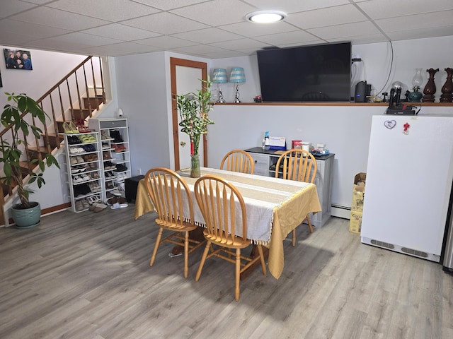 7 Lorraine Ave, Lewiston, ME 04240 - dining area with a baseboard heating unit, wood finished floors, stairs, and a drop ceiling