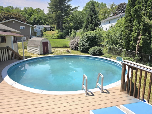 7 Lorraine Ave, Lewiston, ME 04240 - view of pool featuring a deck, a shed, a fenced backyard, and view of wooded area