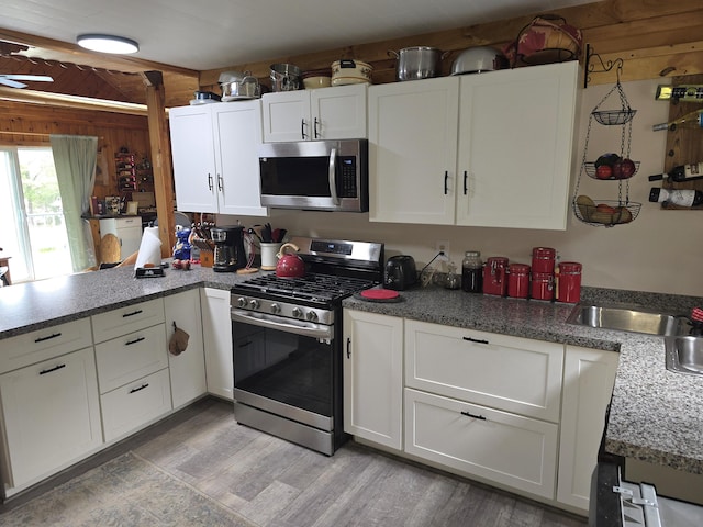 502 Cedar Lake Rd, Millinocket, ME 04462 - kitchen with stainless steel appliances, a peninsula, white cabinetry, and light wood-type flooring