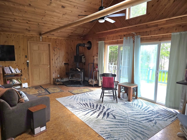 502 Cedar Lake Rd, Millinocket, ME 04462 - living area featuring ceiling fan, a wood stove, wood walls, wood ceiling, and lofted ceiling