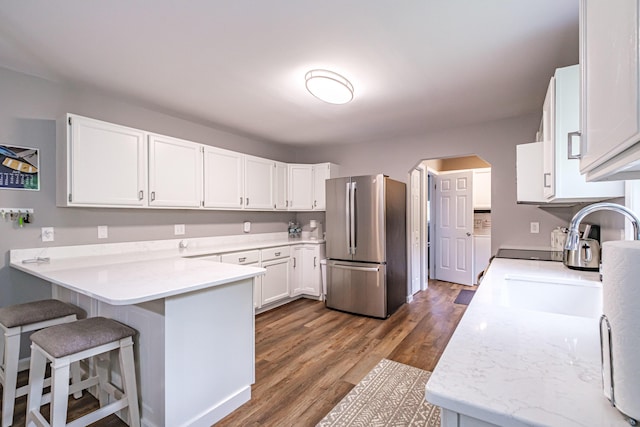 111 Rocky Rd, Woodstock, ME 04219 - kitchen featuring freestanding refrigerator, a peninsula, light countertops, white cabinetry, and dark wood-style flooring