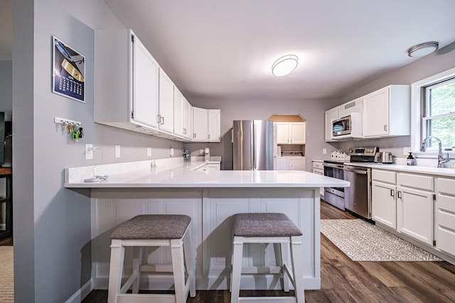 111 Rocky Rd, Woodstock, ME 04219 - kitchen featuring stainless steel appliances, dark wood-style floors, light countertops, arched walkways, and washer and dryer