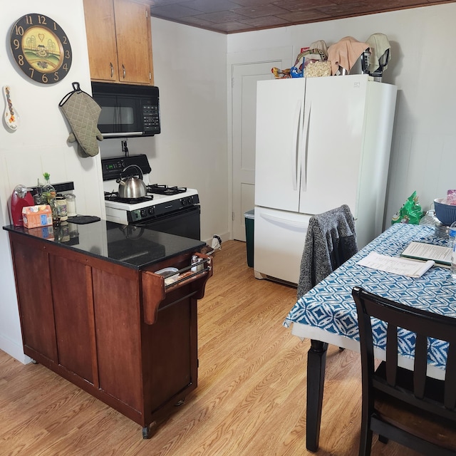 485 Main Rd, Passadumkeag, ME 04475 - kitchen with black microwave, freestanding refrigerator, gas range, and light wood finished floors