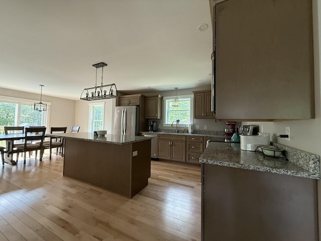 34 May Way, Sidney, ME 04330 - kitchen featuring appliances with stainless steel finishes, a center island, light wood-style floors, and dark stone counters