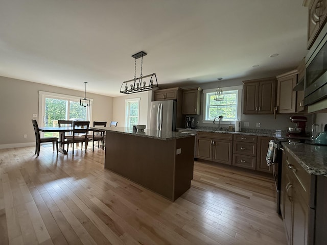 34 May Way, Sidney, ME 04330 - kitchen featuring appliances with stainless steel finishes, a center island, a chandelier, light wood finished floors, and dark stone countertops