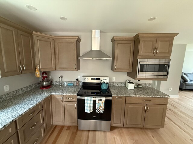 34 May Way, Sidney, ME 04330 - kitchen featuring stainless steel appliances, wall chimney exhaust hood, light wood-style floors, and light stone countertops