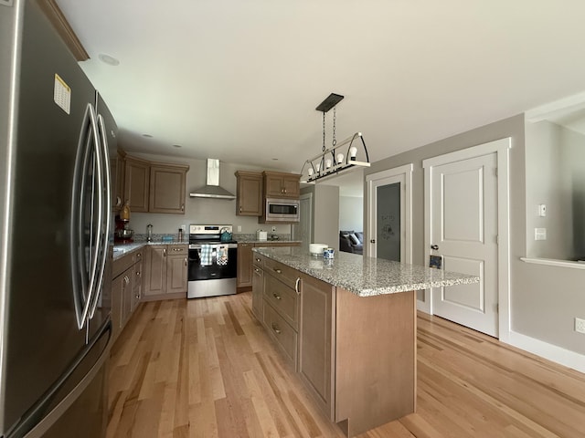 34 May Way, Sidney, ME 04330 - kitchen with appliances with stainless steel finishes, wall chimney range hood, light wood finished floors, and a center island