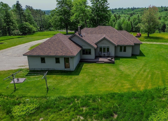 32 Ridge Rd, Marshfield, ME 04654 - rear view of house with a deck, a chimney, a yard, and a shingled roof