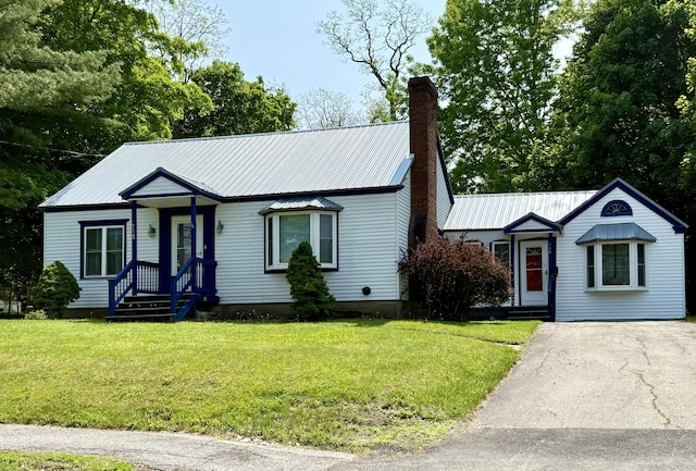 755 Main St, Calais, ME 04619 - view of front of house featuring a chimney, a metal roof, a front yard, and driveway