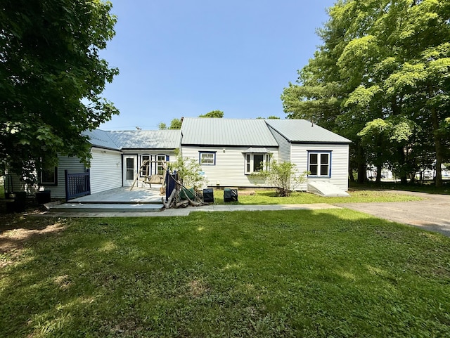 755 Main St, Calais, ME 04619 - back of property with a deck, a lawn, and a metal roof