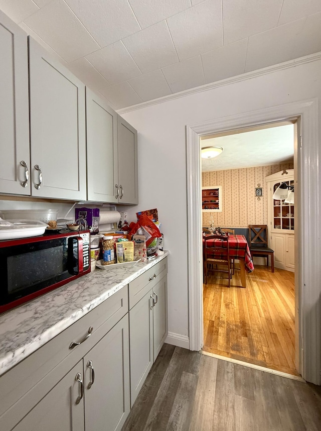 755 Main St, Calais, ME 04619 - kitchen featuring wood finished floors, gray cabinets, and wallpapered walls