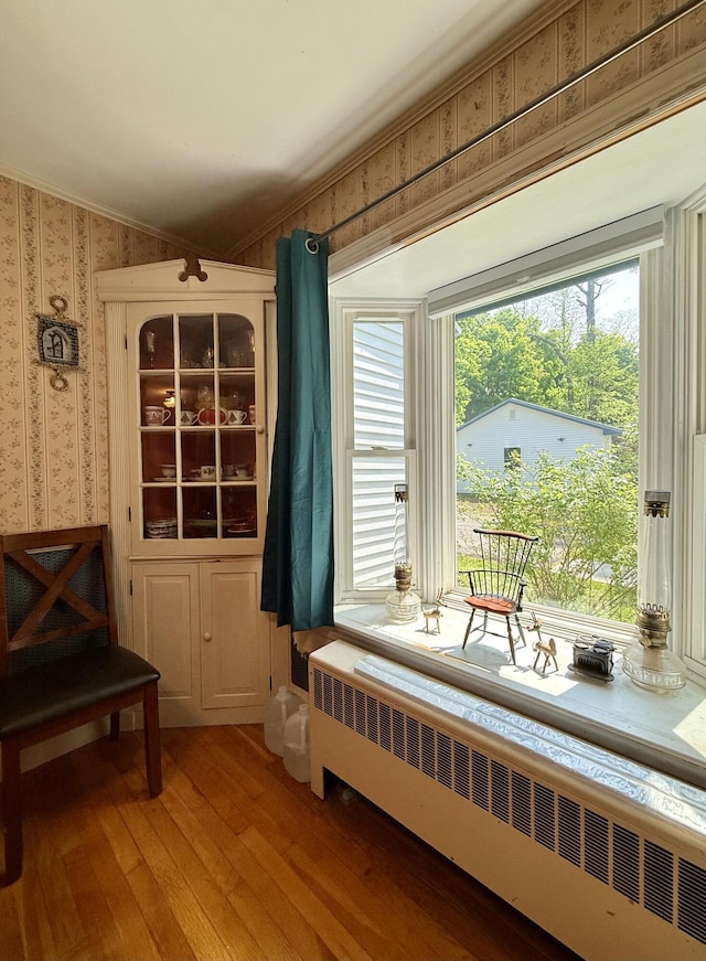 755 Main St, Calais, ME 04619 - living area featuring radiator, wallpapered walls, light wood-style flooring, healthy amount of natural light, and ornamental molding