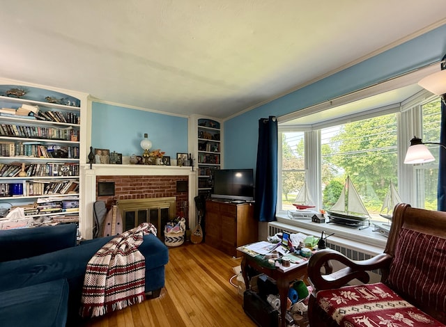 755 Main St, Calais, ME 04619 - living area featuring hardwood / wood-style flooring, a brick fireplace, crown molding, and built in shelves