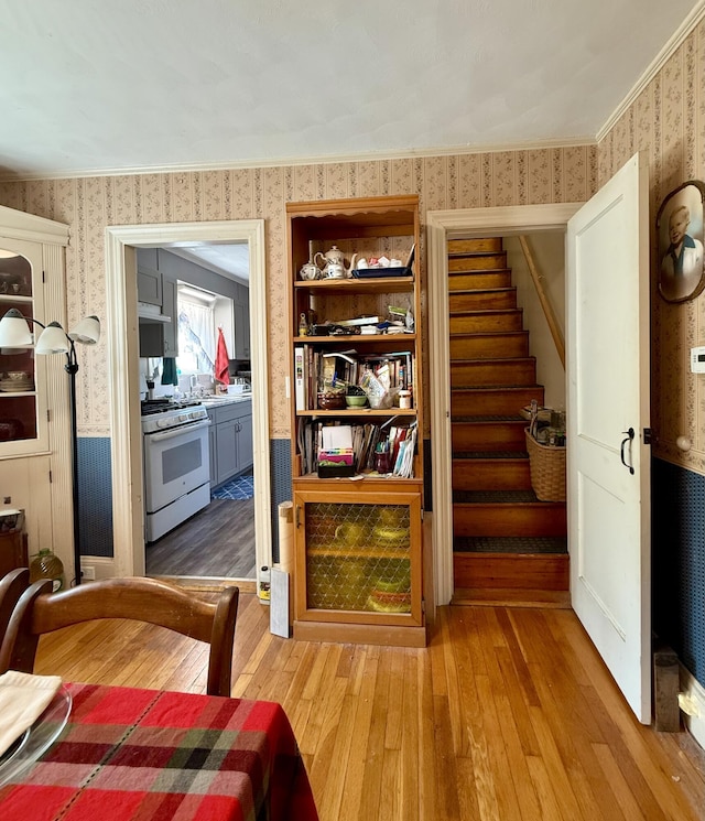 755 Main St, Calais, ME 04619 - interior space featuring wallpapered walls, white gas range oven, wood finished floors, and under cabinet range hood